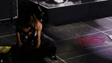 a person is kneeling down on a stage with the letter d visible