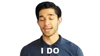 a man in a blue shirt says " i do " with his eyes closed
