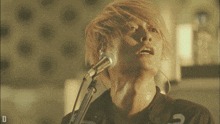 a person singing into a microphone with the letter d on the bottom