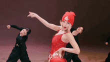 a woman in a red dress and a red beanie is dancing