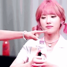 a woman with pink hair is being touched by another woman