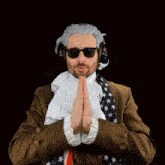 a man wearing sunglasses and a scarf is praying in front of a dark background