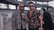 a couple of men standing next to each other with a aew logo on their jacket