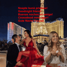a man carrying a woman in a red dress in front of the eiffel tower with a picmix watermark