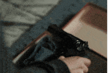 a person is holding a gun in front of a box that says cp