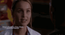 a close up of a woman in a white lab coat talking to a man in a dark room .