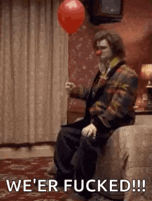 a clown is sitting on a bed holding a red balloon and saying we 're fucked .