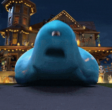 a blue monster is standing in front of a house