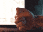 a close up of a person 's fist in front of a computer monitor
