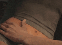a man is touching a woman 's stomach with his hands .