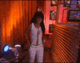 a woman in a white tank top and white pants