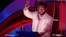 a man sitting in front of a podium with nbc written on the bottom