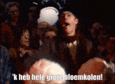 a man in a top hat stands in front of a crowd and says k heb hele grote bloemkolen