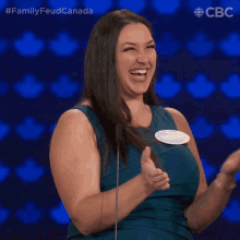 a woman in a blue dress is laughing and has a name tag that says sandra on it