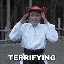 a woman wearing a red cowboy hat is terrified