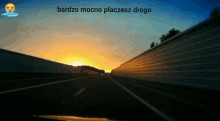 a picture of a highway with the words bardzo mocno placesz drogo
