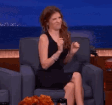 a woman in a black dress is sitting in a chair with the word gross written on the bottom
