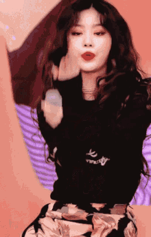 a woman with red lips is wearing a black shirt that says ' a ' on it