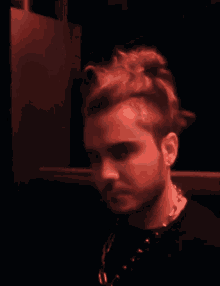 a close up of a man 's face with a beard in red light
