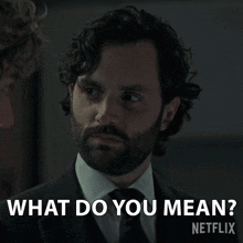 a man in a suit and tie asks what do you mean