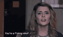 a woman is making a funny face and saying `` you 're a f * cking idiot '' .