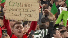 a man is holding a sign that says cristiano please let me touch your