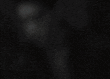 a close up of a man 's face in a dark room
