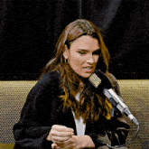 a woman is sitting in front of a microphone that says radio on it