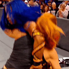 two women are hugging each other in front of a crowd .