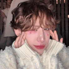 a person wearing a white sweater has a flower on their nose
