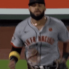 a man with a beard is wearing a baseball uniform and a hat .