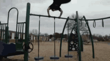 a man is doing a handstand on a playground .