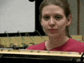 a woman in a red shirt holds a xylophone