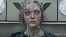 a poster for predator badlands shows a woman with white eyes and scratches on her face