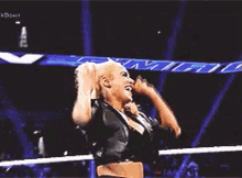 a woman is standing on top of a man in a wrestling ring .