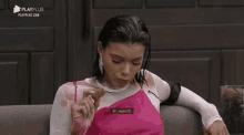 a woman in a pink dress is sitting on a couch