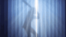 a silhouette of a person is visible behind a blue curtain