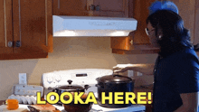 a man cooking on a stove with the words looka here written on the bottom