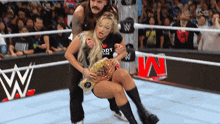 a man is carrying a woman in a wrestling ring wearing a shirt that says ody om