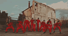 a group of people in red pants are dancing in front of a building that says tumblr
