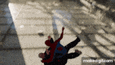 a man in a spider man costume is falling down