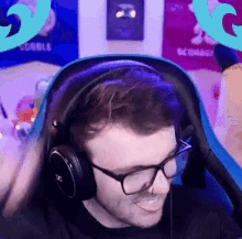 a man wearing headphones and glasses is sitting in a blue chair