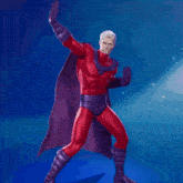 a man in a red superhero costume with a purple cape stands with his arms crossed