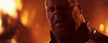 a close up of a man with a beard in front of a fire in a dark room .