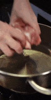 a person is cooking something in a pot of water