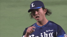 a baseball player with the letter l on his hat is holding a red glove .