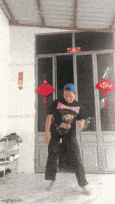 a man is dancing in front of a door that has a sign that says tet on it