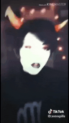 a person wearing a mask with horns on their head is making a tiktok video .