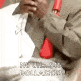 a man in a suit and tie is sitting on a bed holding a cell phone .