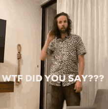 a man in a leopard print shirt is standing in front of a door and says wtf did you say